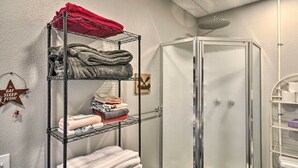 A bathroom with a glass shower enclosure, a metal towel rack with folded towels, and a wall-mounted towel warmer. - Hidden Gem: Dock & Views on Pine Hollow Reservoir! (Tygh Valley)