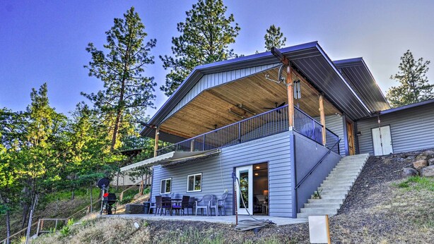 A modern house with a covered porch, a staircase leading to a deck, and a barbecue setup. - Hidden Gem: Dock & Views on Pine Hollow Reservoir! (Tygh Valley)