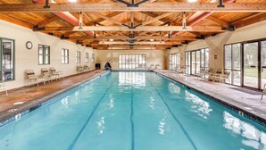 Ein großes Hallenbad mit Holzbalken und einer gefliesten Kante.