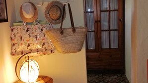 A room with a wooden door, a patterned rug, and a wall-mounted hat rack.