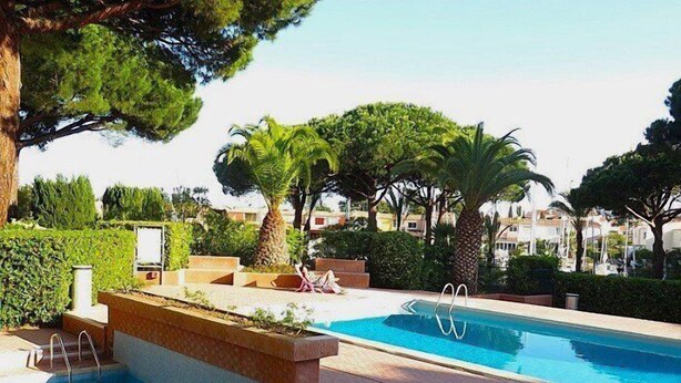 A swimming pool with steps leading into it, surrounded by greenery and trees. - AGREABLE STUDIO EN REZ DE JARDIN AVEC GRANDE TERRASSE (LE CAP D AGDE)