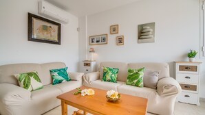 A living room with two sofas, a wooden coffee table, and a small side table with a lamp.