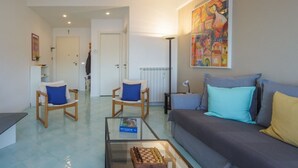 A living room with a sofa, two armchairs, a coffee table with a chessboard, a radiator, and a painting on the wall. - CASA LINDA - Dream view, swimming pool, and tennis court (Rapallo)