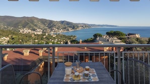 A balcony with a table set for tea, overlooking a coastal town and the sea. - CASA LINDA - Dream view, swimming pool, and tennis court (Rapallo)