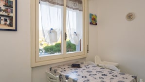 A room with a table and chairs, a window with curtains, a clock on the wall, and a framed picture. - CASA LINDA - Dream view, swimming pool, and tennis court (Rapallo)
