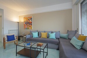 Een woonkamer met een bank, een salontafel, een stoel en een radiator.