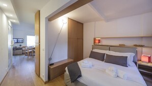 Habitació d'hotel amb un llit, taules de nit, un escriptori i una cadira.