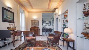 A traditional living room with a television, leather armchairs, a coffee table, and a bookshelf with model ships. - VILLA AURORA - Relax with Sea View and Swimming Pool (Camogli)