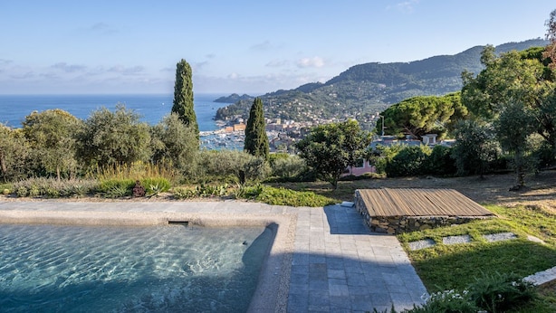 Une piscine avec vue sur la mer et les collines.
