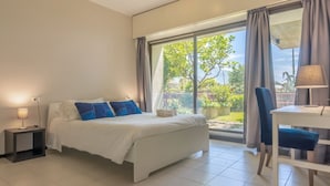 A bedroom with a bed, a bedside table, a desk with a chair, and a large window with curtains. - HAPPY HOLIDAY - Open space with sea view (Camogli)