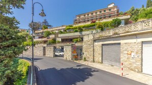 A street with a stone building, a car, and a pedestrian crossing. - HAPPY HOLIDAY - Open space with sea view (Camogli)