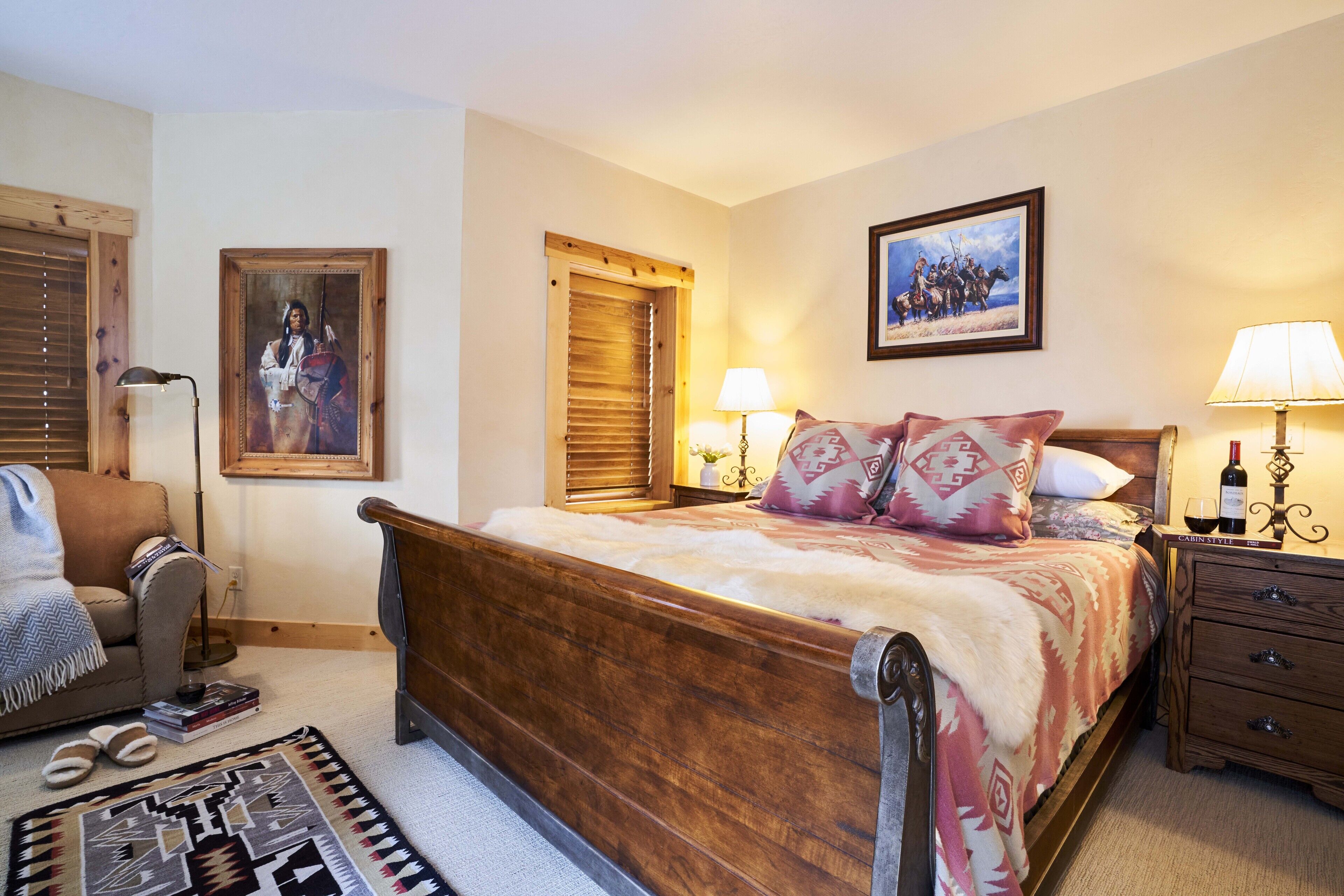 Une chambre à coucher avec un lit en bois, une table de chevet avec une lampe, une chaise et un tapis.