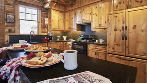 Eine Holzhüttenküche mit Holzausbau, einer schwarzen Arbeitsplatte und einer Kaffeetasse.