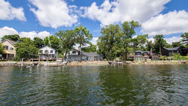 Una zona residenziale sul lago, con case, pontili e alberi.