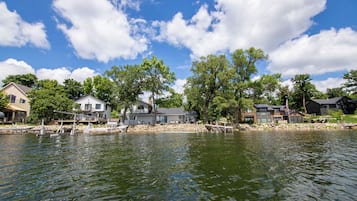 Un quartier résidentiel au bord d’un lac, avec des maisons, des quais et des arbres.