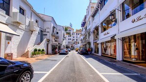 A street with buildings on either side, including a hotel with a sign that reads "HOTEL". - 1079 - FRONTLINE PUERTO BANUS APARTMENT (Marbella)