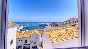 A coastal town with white buildings, a marina, and boats. - 1079 - FRONTLINE PUERTO BANUS APARTMENT (Marbella)