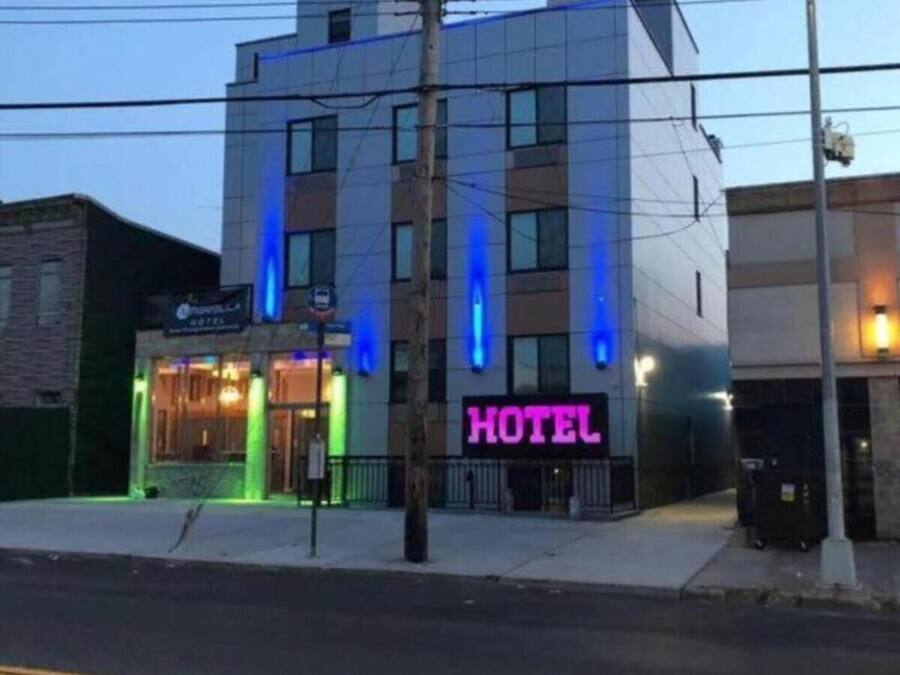 A modern hotel building with a prominent 'HOTEL' sign in neon lights.