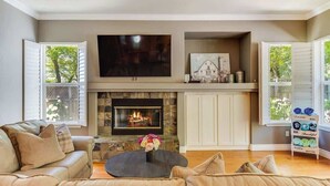 A living room with a fireplace, a sofa, and a coffee table. - Wine Country Harvest Vacation Home (Santa Rosa)