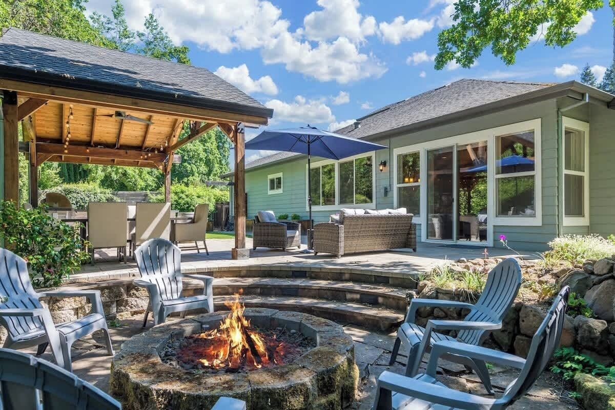 Un patio al aire libre con un brasero, asientos y una zona cubierta.
