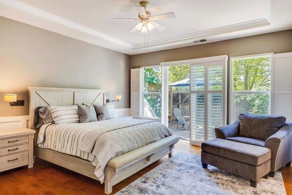 A bedroom with a bed, a nightstand, a chair, and a ceiling fan. - Wine Country Harvest Vacation Home (Santa Rosa)