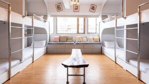 A room with bunk beds, a central table, and large windows with city views. - May Rooms Taipei Main Station (Taipei)