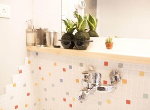 A bathroom with a tiled backsplash, a sink, a mirror, and a hairdryer on the countertop. - May Rooms Taipei Main Station (Taipei)