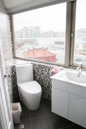 A compact bathroom with a toilet, sink, and window. - May Rooms Taipei Main Station (Taipei)