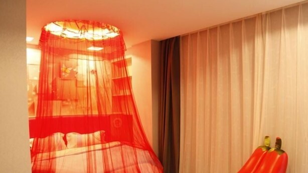 A hotel room with a bed, a red chair, and a sheer red canopy over the bed. - Shell Nanjing Yuhuatai District Meishan Town Wanghai Pedestrian Street Hotel (Nanjing)