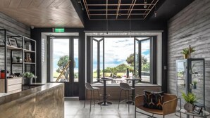 Un intérieur moderne comprenant un comptoir d’accueil, un espace de détente et de grandes fenêtres offrant une vue sur l’extérieur.