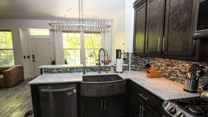 Una cocina moderna con lavavajillas, pileta y estufa.