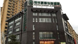 A multi-story building with a prominent sign for a hotel. - Greentree Inn Henan Xinyang Shangcheng County Huangbaishan Road Times Shopping Mall Express Hotel (Xinyang)