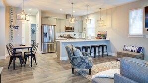 A modern kitchen with a central island, stainless steel appliances, and pendant lighting.