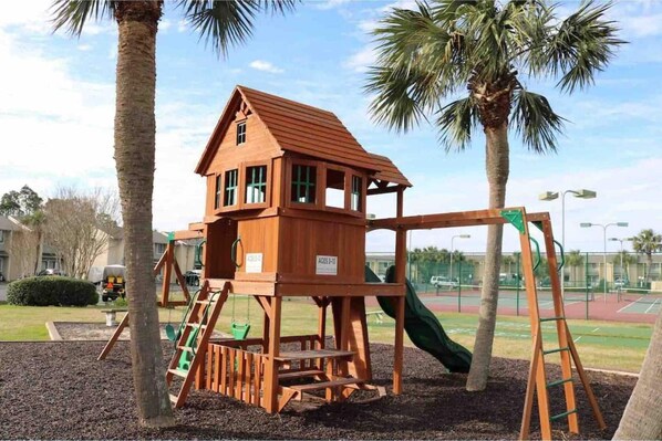 Kids can play on the outdoor play structure with a slide, swing set, and climbing ladder.