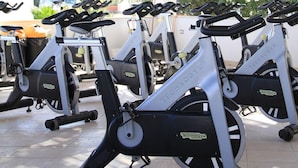 A covered outdoor area with multiple stationary bikes labeled "TECHNOGYM". - Gran Torre Hotel (Cabras)