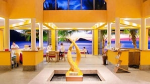 A lobby with a central sculpture, seating areas, and a view of the beach at night. - Siam Royal View Resort Apartments (Koh Chang)