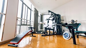 A gym with exercise equipment, large windows, and a wooden floor. - Greentree Inn Bozhou Lixin District Huishang Market (Bozhou)