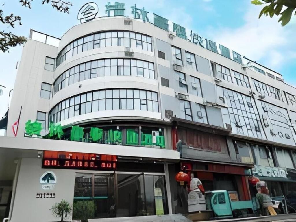 A multi-story building with a curved facade, large windows, and signage indicating a business or commercial use.