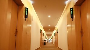 A hotel hallway with wooden doors, numbered room signs, and a carpeted floor. - Greentree Inn Huainan Jinjialing Road Oriental General Hospital (Huainan)