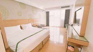 A hotel room with a large bed, a desk, a chair, a television, and a window with curtains. - Greentree Inn Huainan Jinjialing Road Oriental General Hospital (Huainan)