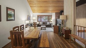 Una sala acogedora con una mesa de comedor de madera, un sofá y una chimenea.