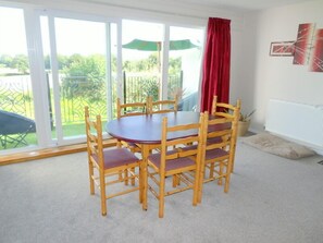 A room with a round table and six wooden chairs with cushioned seats. - Sleeps6- Countryside Privacy- 30MinToBeach (Callington)
