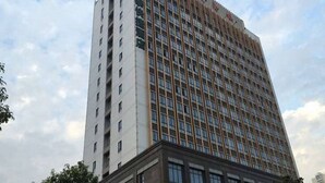 Un edificio de hotel alto con varios pisos y un letrero llamativo en la parte superior.