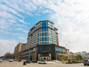 A multi-story hotel with a prominent corner entrance, large windows, and a visible flag. - Greentree Eastern Yingtan City Guixi Municipal Government Hotel (Yingtan)