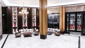 A modern lobby with a central seating area, tall wooden columns, and a large window with a city view. - Greentree Eastern Yingtan City Guixi Municipal Government Hotel (Yingtan)