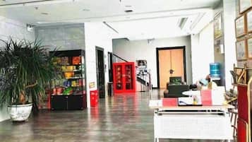 A reception area with a plant, a vending machine, and a counter with informational materials.