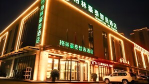 A hotel with a prominent GreenTree Inn sign, large glass entrance, and a well-lit facade. - Greentree Inn Datong High Speed Railway Station Wa (Datong)