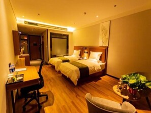 A hotel room with two beds, a desk, a chair, and a small table with a plant. - Greentree Inn Datong High Speed Railway Station Wa (Datong)