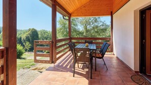 An outdoor patio with a wooden table and chairs, a view of trees, and a clear sky. - Kyjov u Krásné Lípy by Interhome (Krasna Lipa)
