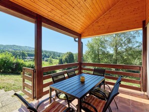 A covered outdoor seating area with a table and chairs, overlooking a scenic landscape. - Kyjov u Krásné Lípy by Interhome (Krasna Lipa)